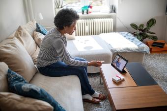 Older woman talking to doctor on computer video chat in living room 