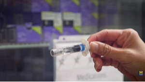 Close up of bare hand holding a small medical needle devise