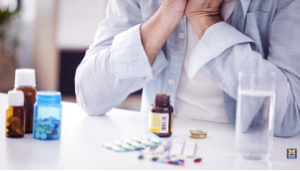 an collection of medications on a table top with a person in deep thought