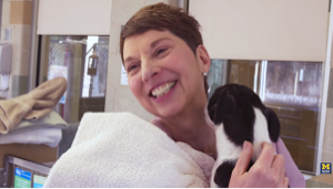 Woman holding a small animal in a hospital environment