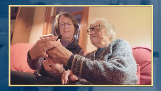 Woman helping mother with mobile device