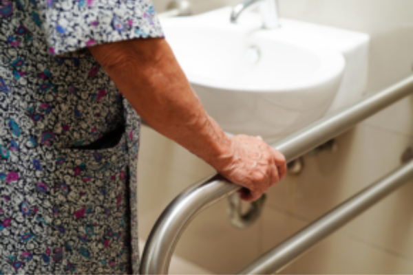 an older person grabbing a bar in a bathroom
