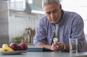Man reading the label on a pill bottle