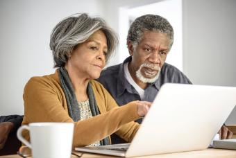 Older couple logging in to a patient portal on their laptop