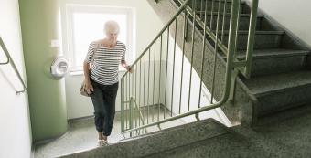 An older person walking up stairs