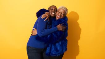 two older woman laughing and hugging each other