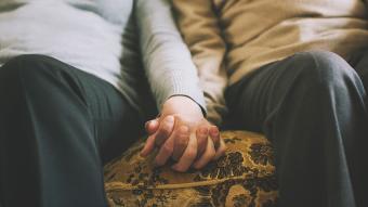 couple holding hands on a couch