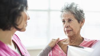 A doctor comforting a patient reviewing test results