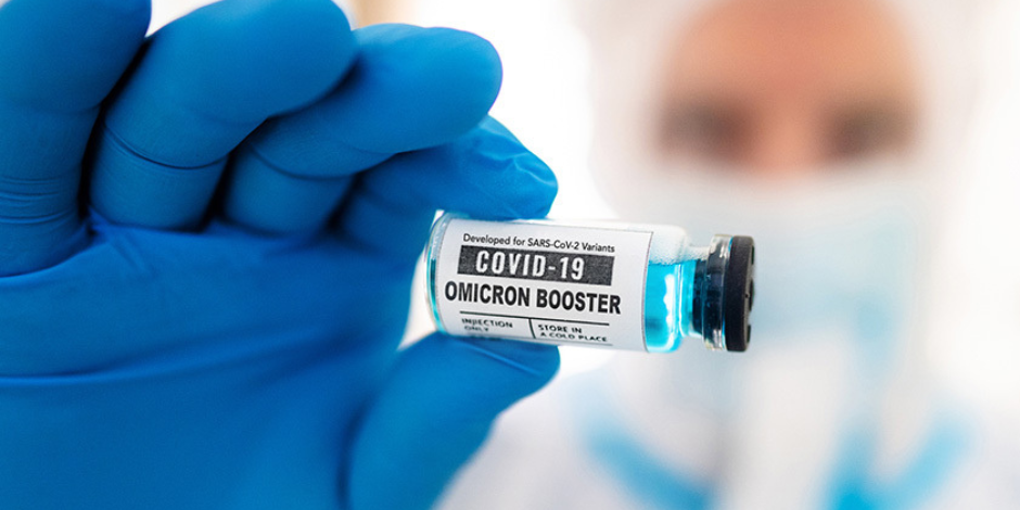 A lab tech holding a vial of the omicron-specific COVID vaccine