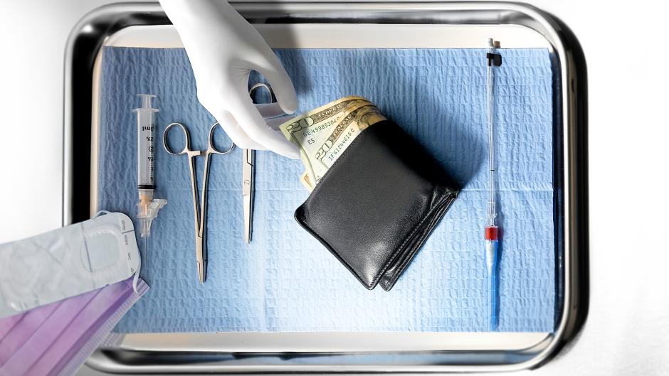 view of tray with surgeon's hand reaching to cash in a wallet