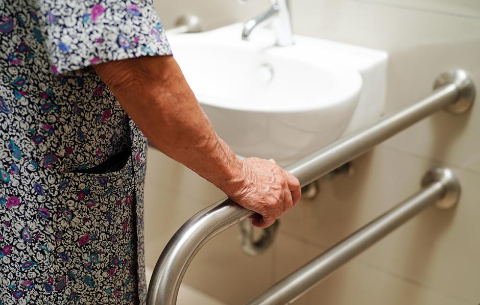 older person grabs a bar in bathroom